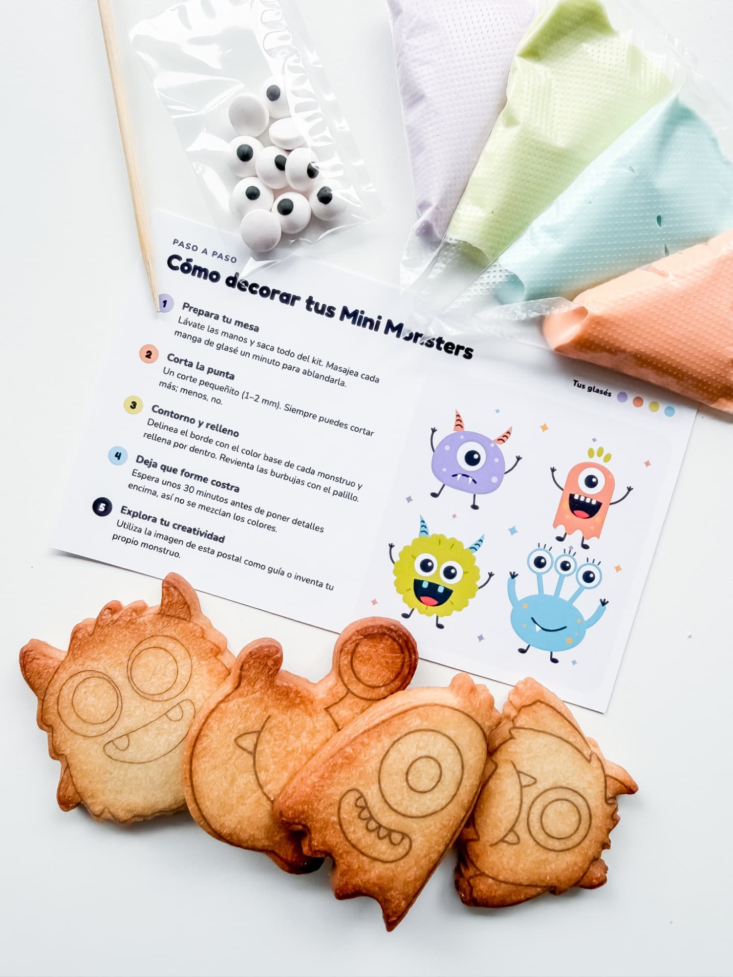 Kit Minis Monsters: cuatro mini galletas de monstruos con guías, mangas de glasé de colores, ojitos de azúcar, palillo y tarjeta de instrucciones